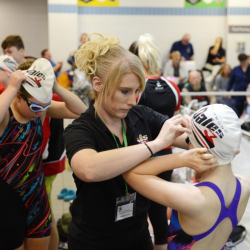 Swim coach helping with swim cap
