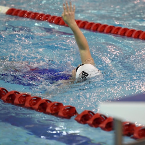 Swimmer doing backstroke in swimming pool