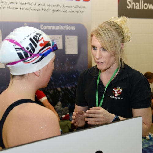 Coach talking to younf swimmer